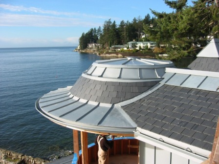 Curved zinc standing seam cladding wrapping the turret of an oceanfront West Vancouver home